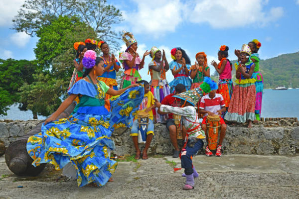 A group of young Panamenians performing the Congo dance in one of the Spanish fortresses (hence the cannons) of Portobelo by the Caribbean Sea, Panama, Central America.